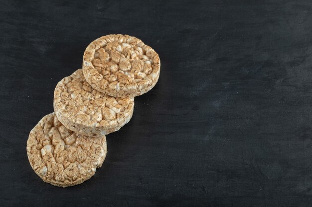 Pile of crispy rice cakes on black surface