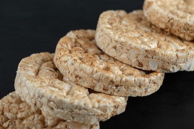 Pile of crispy rice cakes on black surface