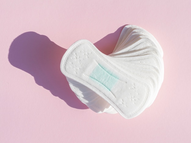 Pile of daily clean sanitary towels on pink background