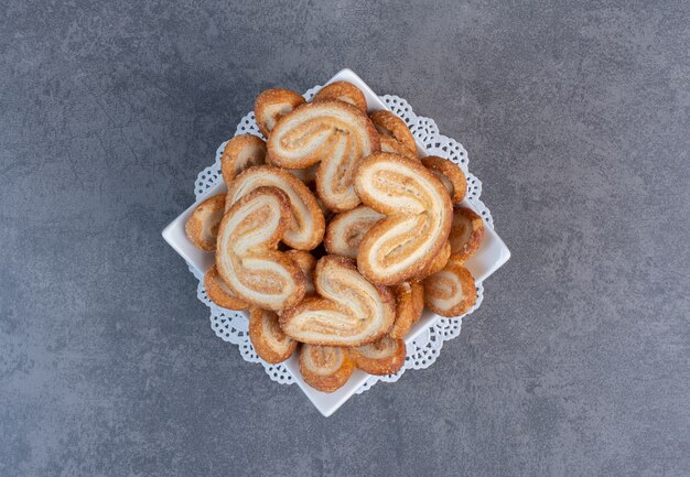 Pile of delicious biscuits in white bowl.