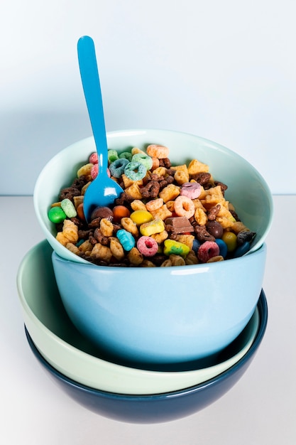 Pile of dirty blue bowls filled with cereal fruit loops