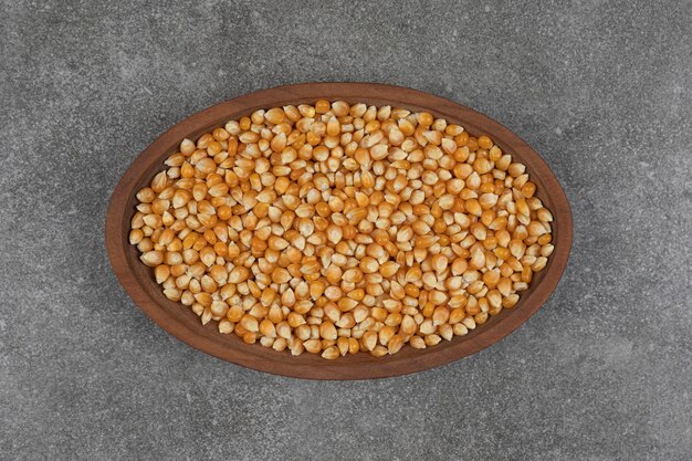 Pile of dried corns on wooden plate.