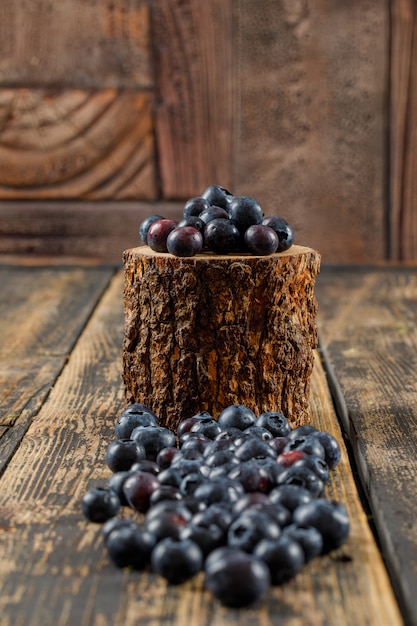 Куча свежих ягод черники в деревянный кусок на деревянный стол