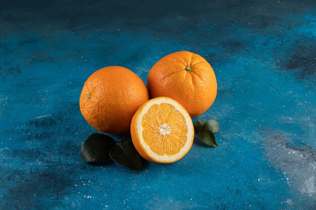 A pile of fresh orange, on the blue surface