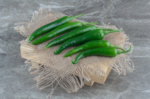 Foto gratuita mucchio di peperoncini verdi hit n sacco su superficie grigia