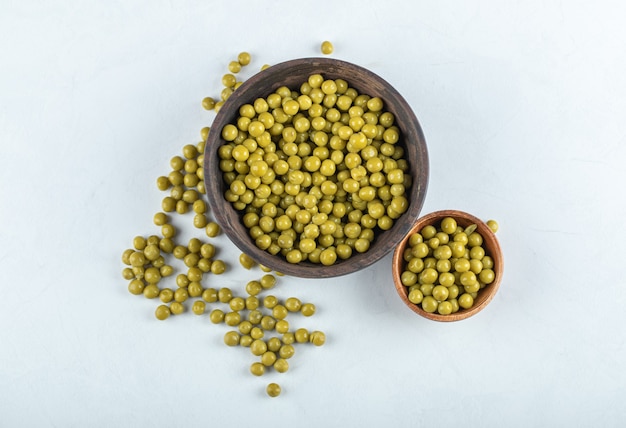 Pile of green peas in bowl and table.