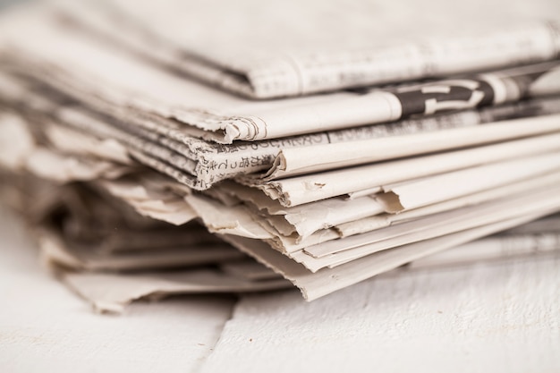 Free photo pile of newspapers on a white table