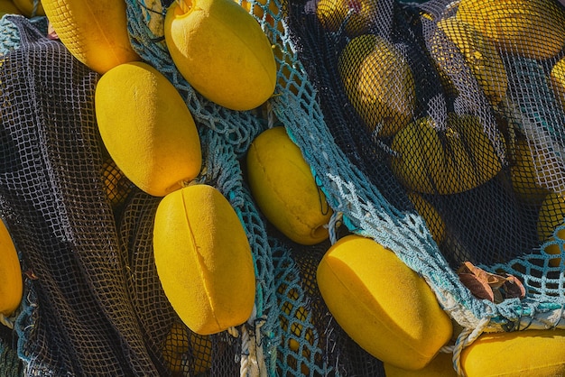 無料写真 黄色のフロートと色とりどりの漁網の山は、桟橋のクローズ アップの選択と集中で乾燥した沿岸の町での伝統的な釣りの概念の背景