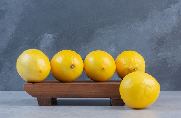 Free photo pile of organic lemon on wooden board .