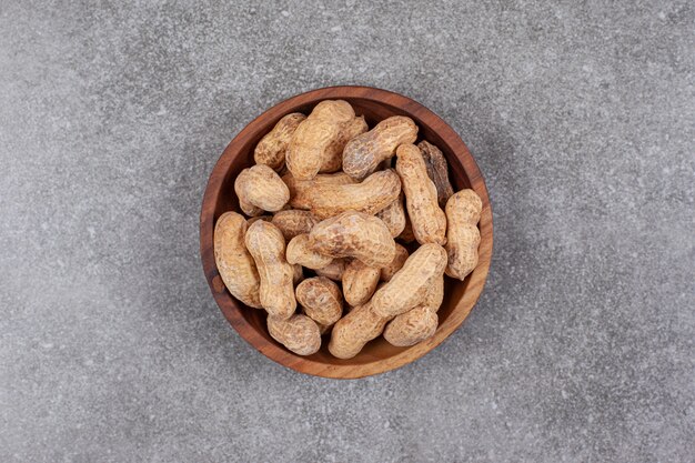 Pile of organic peanuts in wooden bowl