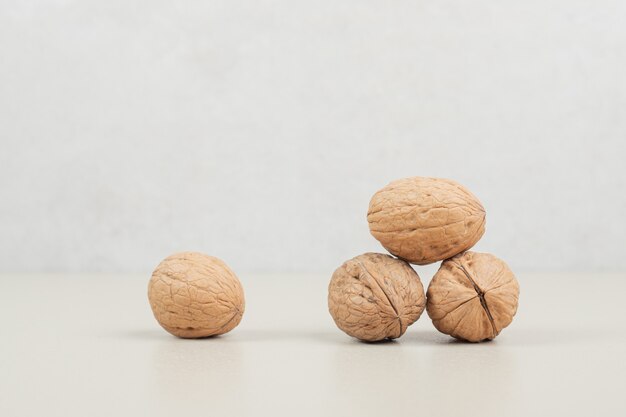 Pile of organic walnuts on beige surface