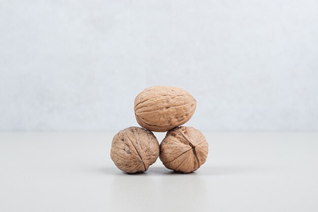 Pile of organic walnuts on beige surface