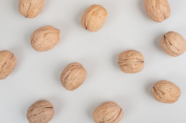 Pile of organic walnuts on beige surface