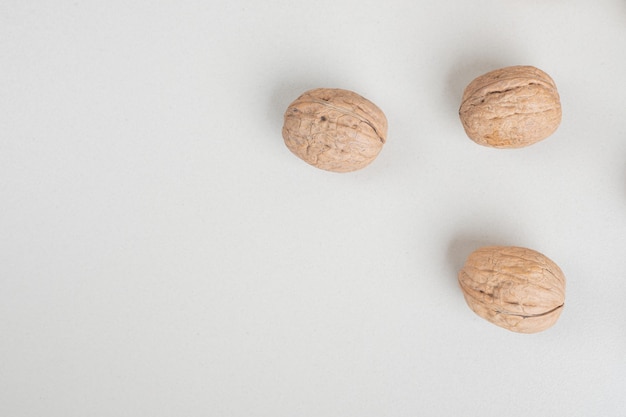 Pile of organic walnuts on beige surface