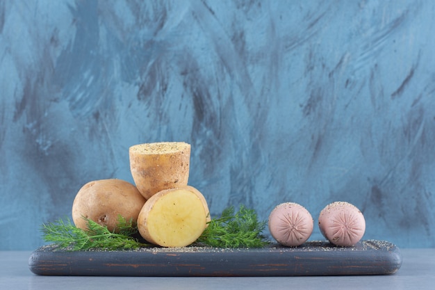 Pile of potatoes lying on black wooden boards. 