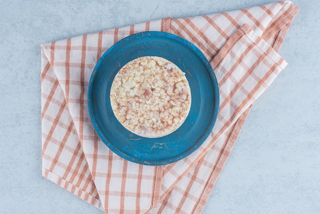 Foto gratuita pila di torte di riso soffiato sul piatto di legno sul tovagliolo su marmo.