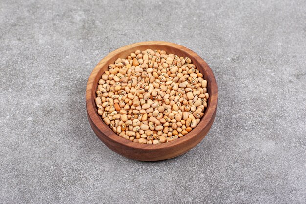 Pile of raw beans in wooden bowl