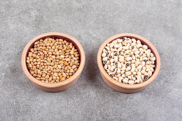 Pile of raw beans in wooden bowls