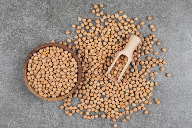 Pile of raw yellow peas in wooden bowl.