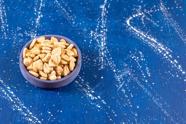 Pile of salted heart-shaped crackers placed in blue bowl