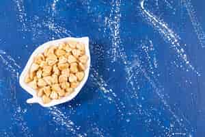 Free photo pile of salted heart-shaped crackers placed on leaf-shaped plate.