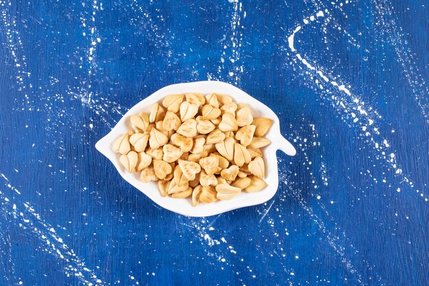 Free photo pile of salted heart-shaped crackers placed on leaf-shaped plate