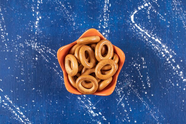 Pile of salted round pretzels placed in orange bowl