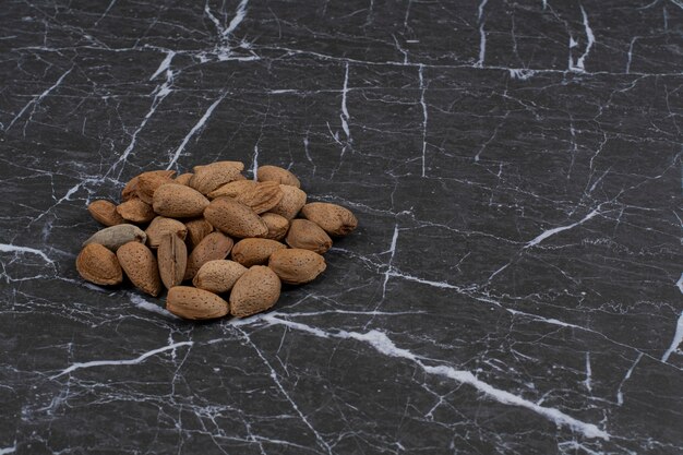 A pile of shelled almonds, on the marble surface