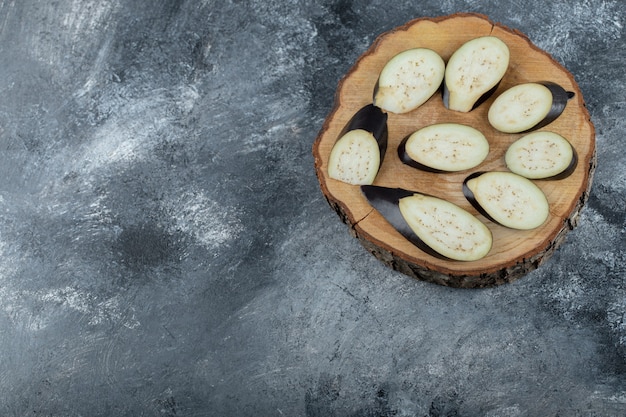 Pile of sliced aubergine on wooden board. Top view.