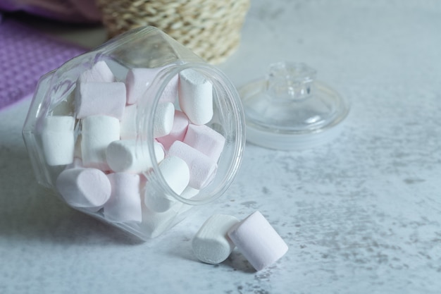 Pile of soft marshmallows out of glass bowl.