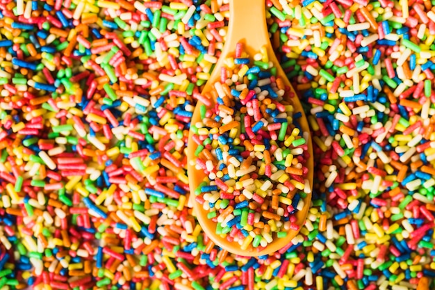 Pile of sprinkles and wooden spoon