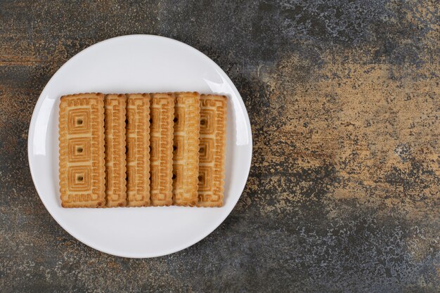 하얀 접시에 맛있는 비스킷의 더미입니다.