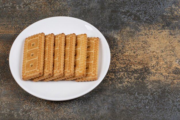 하얀 접시에 맛있는 비스킷의 더미입니다.