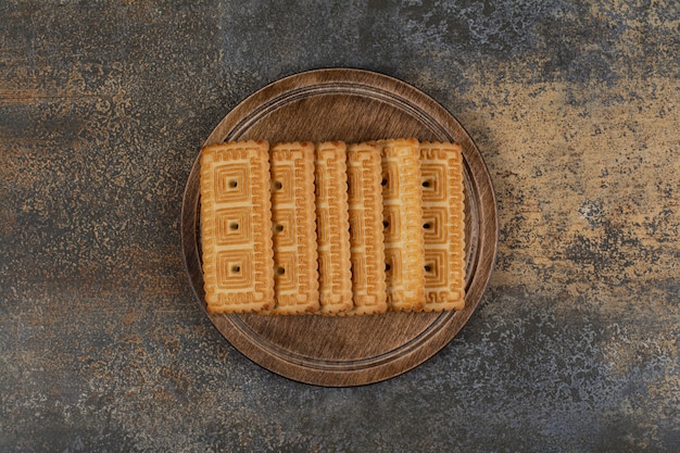 Pila di gustosi biscotti su tavola di legno.