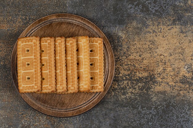Pile of tasty biscuits on wooden board. 