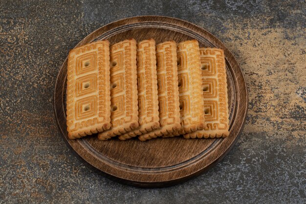 Pile of tasty biscuits on wooden board. 