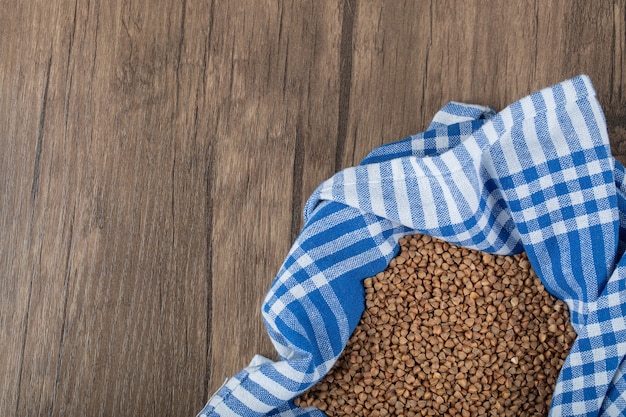 Pile of uncooked buckwheat on wooden table