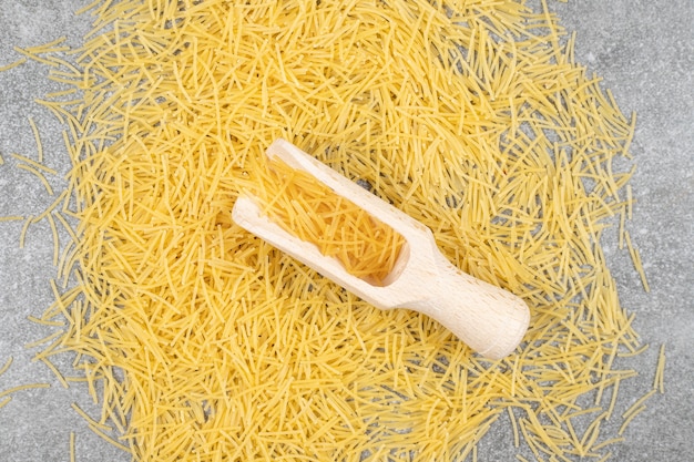 Pile of uncooked pasta on marble surface