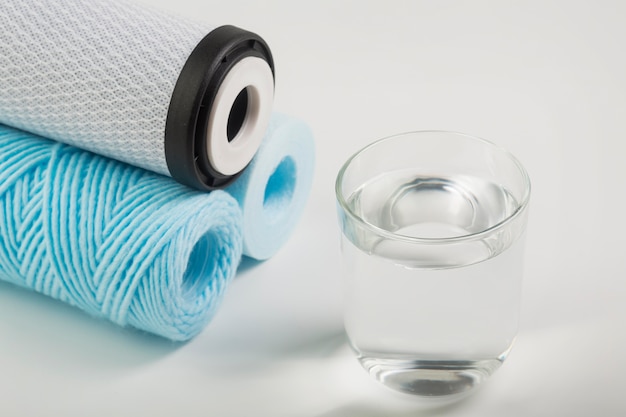 Pile of water filters and glass of water