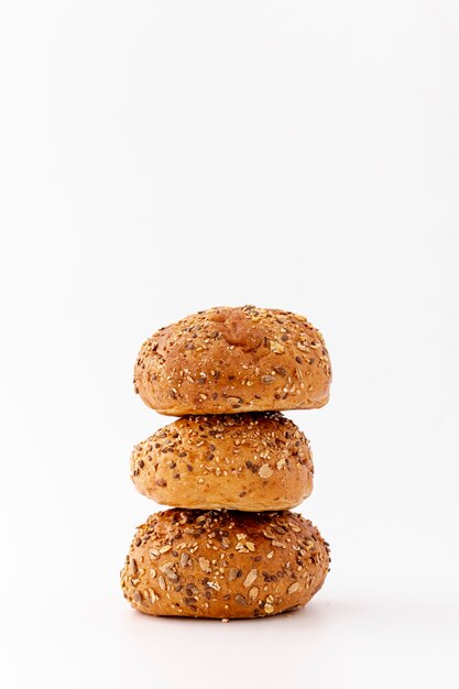 Pile of wholegrain baked buns on white background