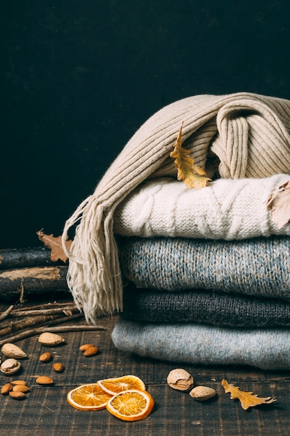 Pile of winter sweaters with leaves