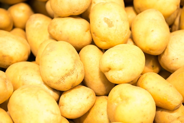 Pile of yellow potatoes at vegetable market. can be used as food background
