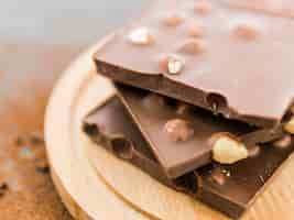 Free photo piled nut chocolate slices on wooden plate