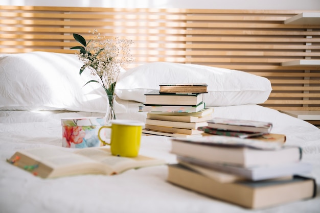 Free photo piles of books lying on bed