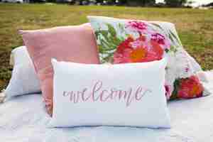 Free photo pillows in the garden with floral print and with a writing 