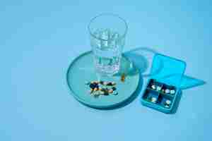 Бесплатное фото Контейнер для таблеток на синем фоне