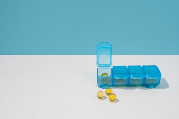 Contenitore per pillole sul tavolo bianco