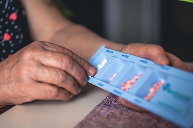 Foto gratuita pillole nelle mani di un primo piano della donna anziana