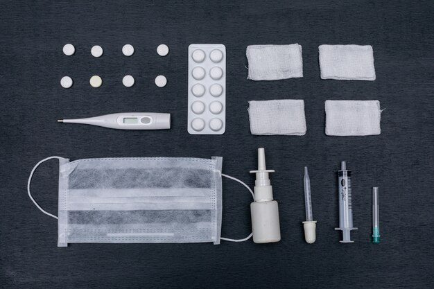 Pills, mask, nasal spray with pipette, thermometer and bandage