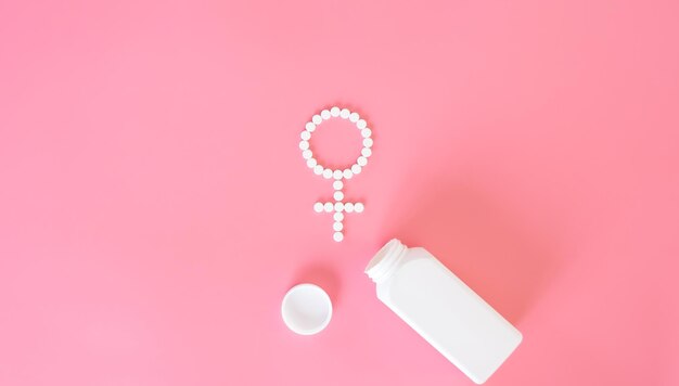 ピンクの背景の錠剤フラットは、女性の健康を築きました